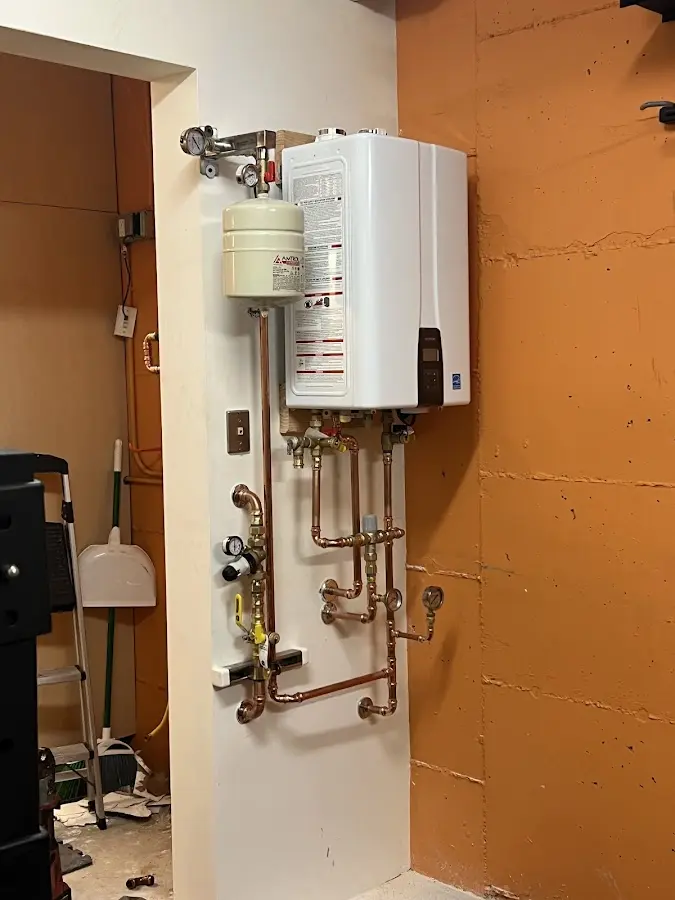 Plumbing technician inspecting water heater connections in Palm Valley